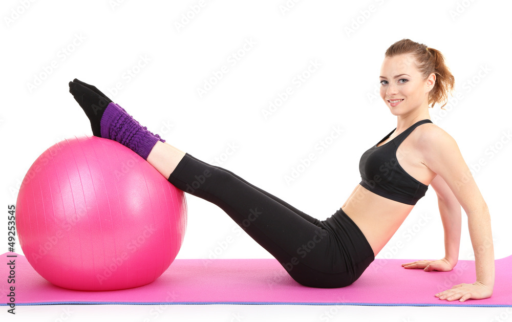 Fototapeta premium Young woman doing fitness exercises with gym ball isolated