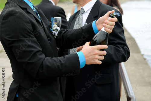 The groomsman with a champagne bottle