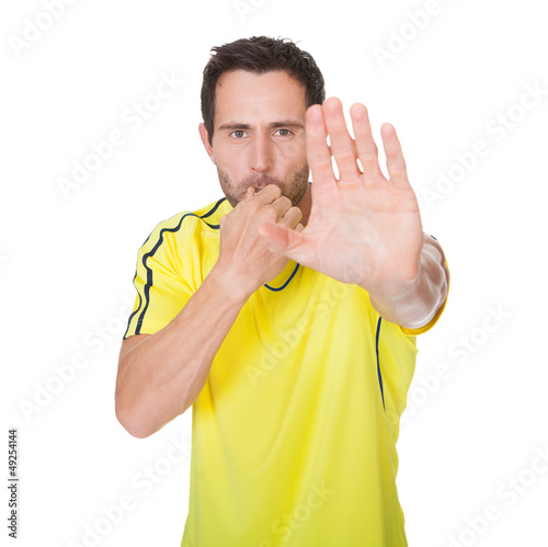 Obraz na plátně Soccer judge whistling and showing stop sign