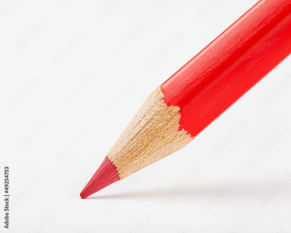 Obraz premium red pencil draws or writing on white paper sheet