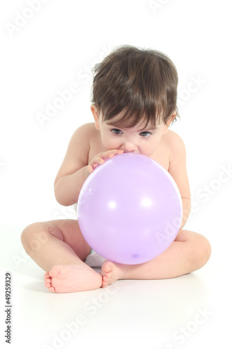 Baby trying to inflate a balloon