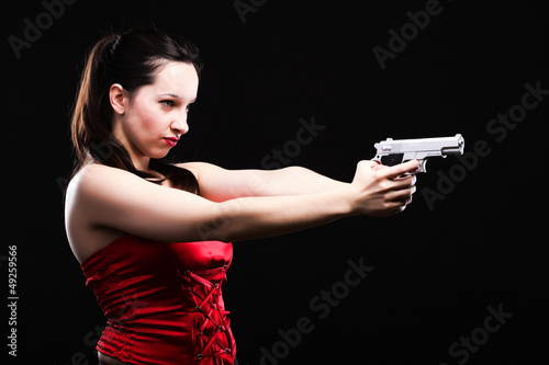 Sexy young woman - gun on black background