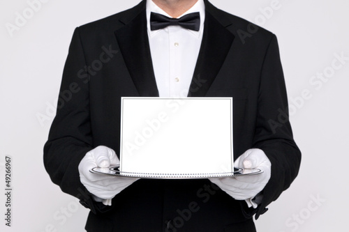 Butler holding a blank card upon a silver tray