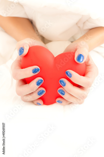 Beautiful woman's hands holding big red heart