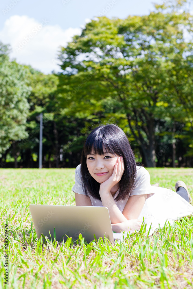 atractive asian woman using laptop in the park atractive asian woman using laptop in the park