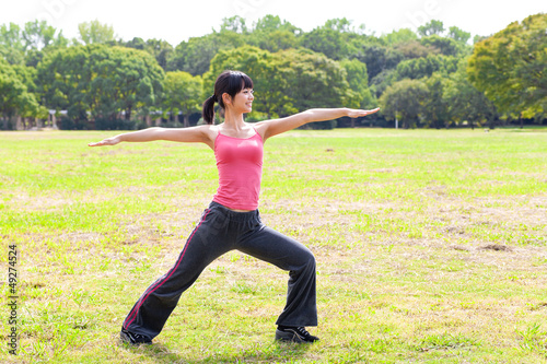 attractive asian woman stretching in the park