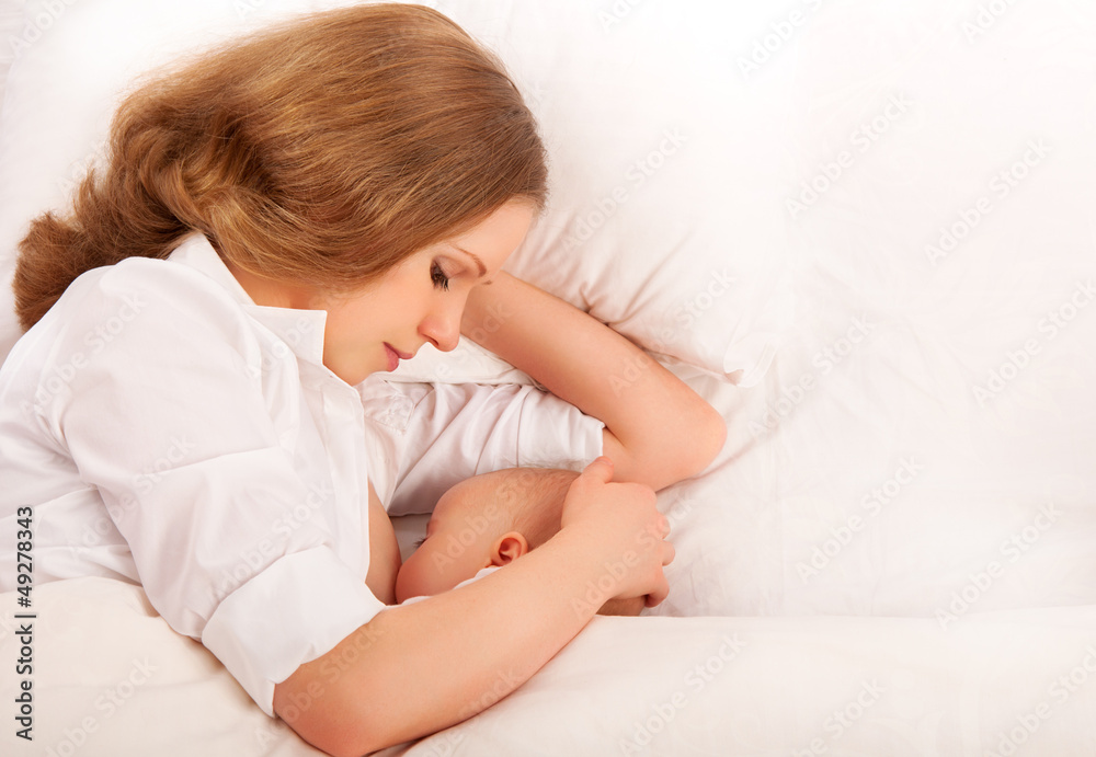 mother feeding her baby in the bed. sleeping together mother feeding her baby in the bed. sleeping together