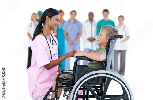Nurse chatting with little boy in wheelchair