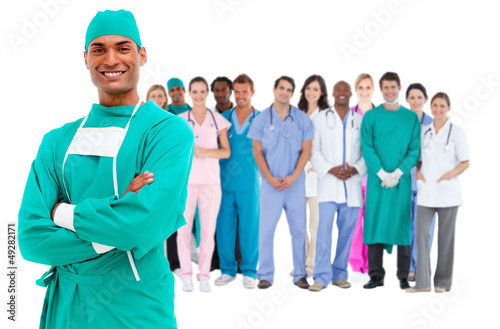 Smiling surgeon with medical staff behind him
