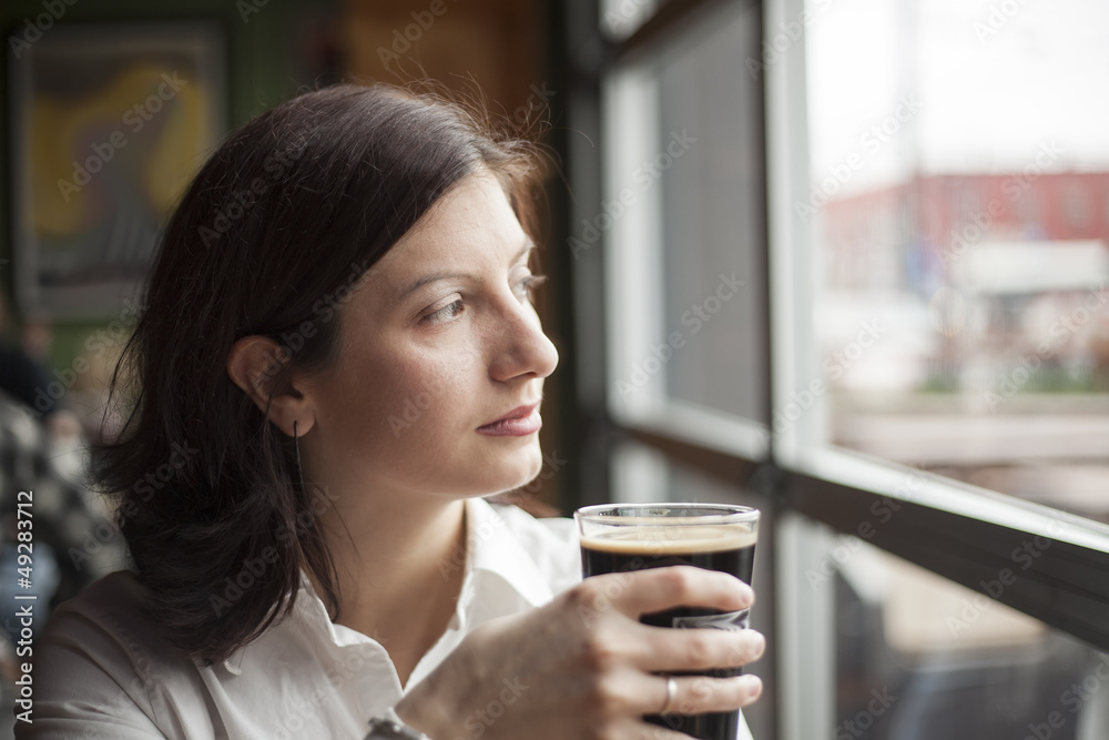 Young Woman with Beautiful Brown Eyes Drinking a Pint of Stout Young Woman with Beautiful Brown Eyes Drinking a Pint of Stout