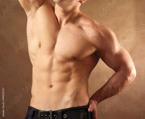 Muscular man , isolated on brown background