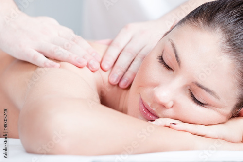 Woman receives body professional massage at spa salon, close up