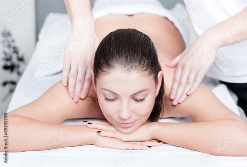Woman receives relaxing body massage at beauty salon