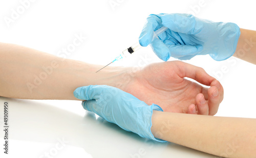 Doctor holding syringe with a vaccine in the patient hand,