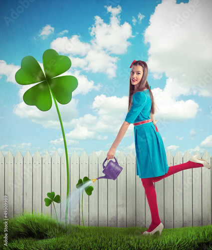 Woman watering a four leaf clover photo