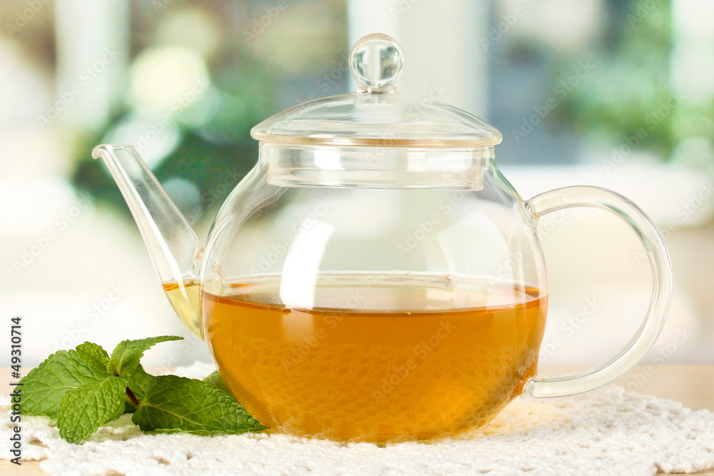 Teapot with mint on table in room Teapot with mint on table in room