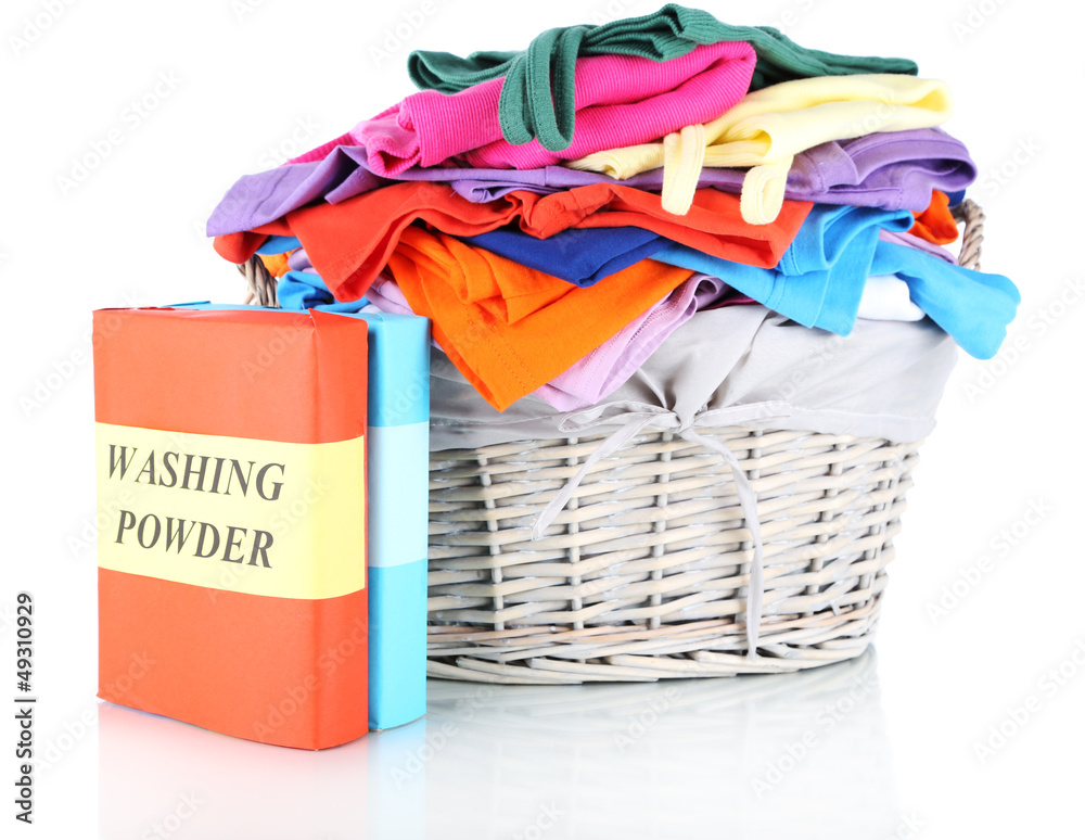 Clothes with washing powder in wooden basket isolated on white Clothes with washing powder in wooden basket isolated on white