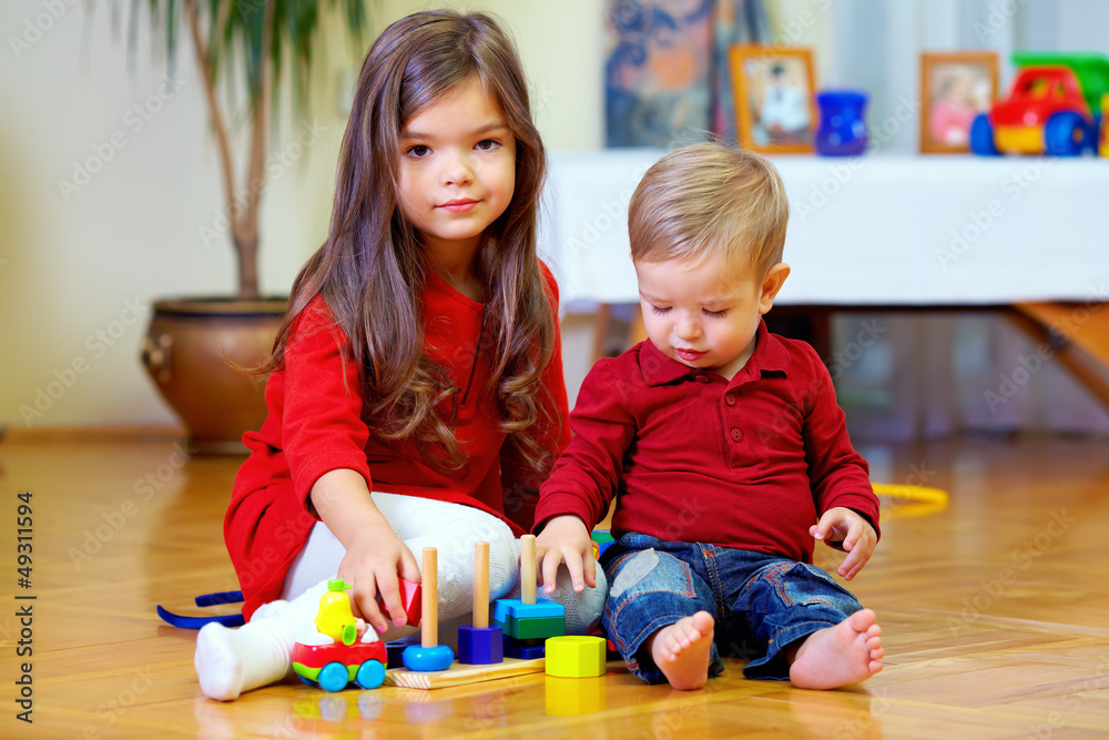 Naklejka premium beautiful brother and sister playing at home