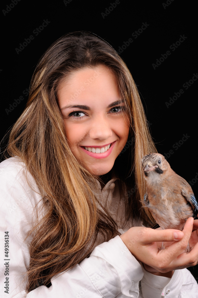 Portrait of smiling girl with bird on the hand