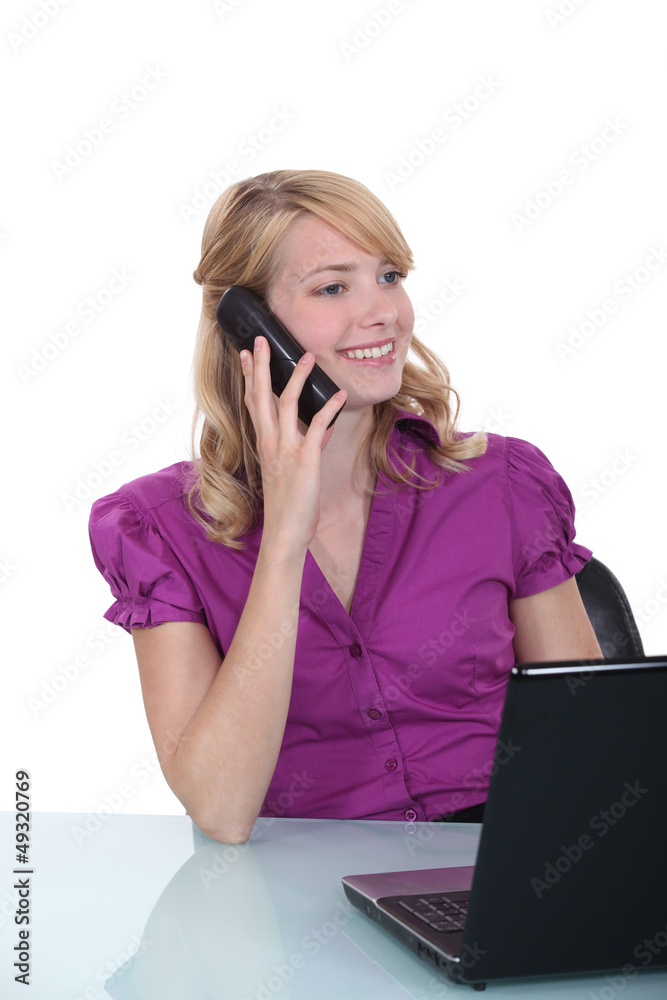 businesswoman sitting at her desk and talking on the phone businesswoman sitting at her desk and talking on the phone