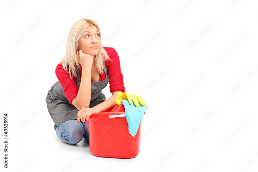 Exhausted female cleaner sitting next to a bucket Exhausted female cleaner sitting next to a bucket