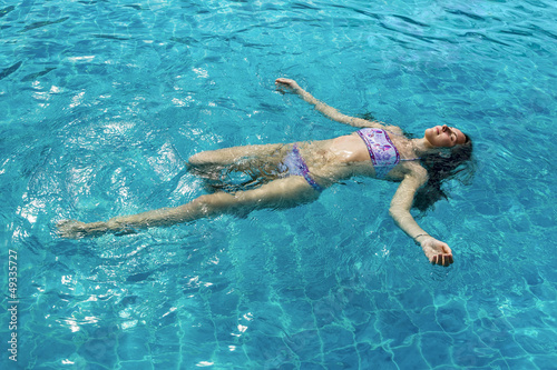 Attractive woman floating in the pool