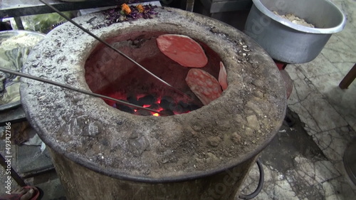 baking chapati in Delhi street market, India