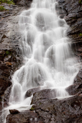 Fototapeta Naklejka Na Ścianę i Meble -  Mountain waterfall over and around rocks