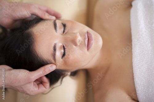 Gorgeous young woman getting a head massage at a spa