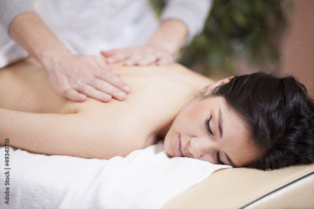Very relaxed young woman getting a back massage at a spa Very relaxed young woman getting a back massage at a spa