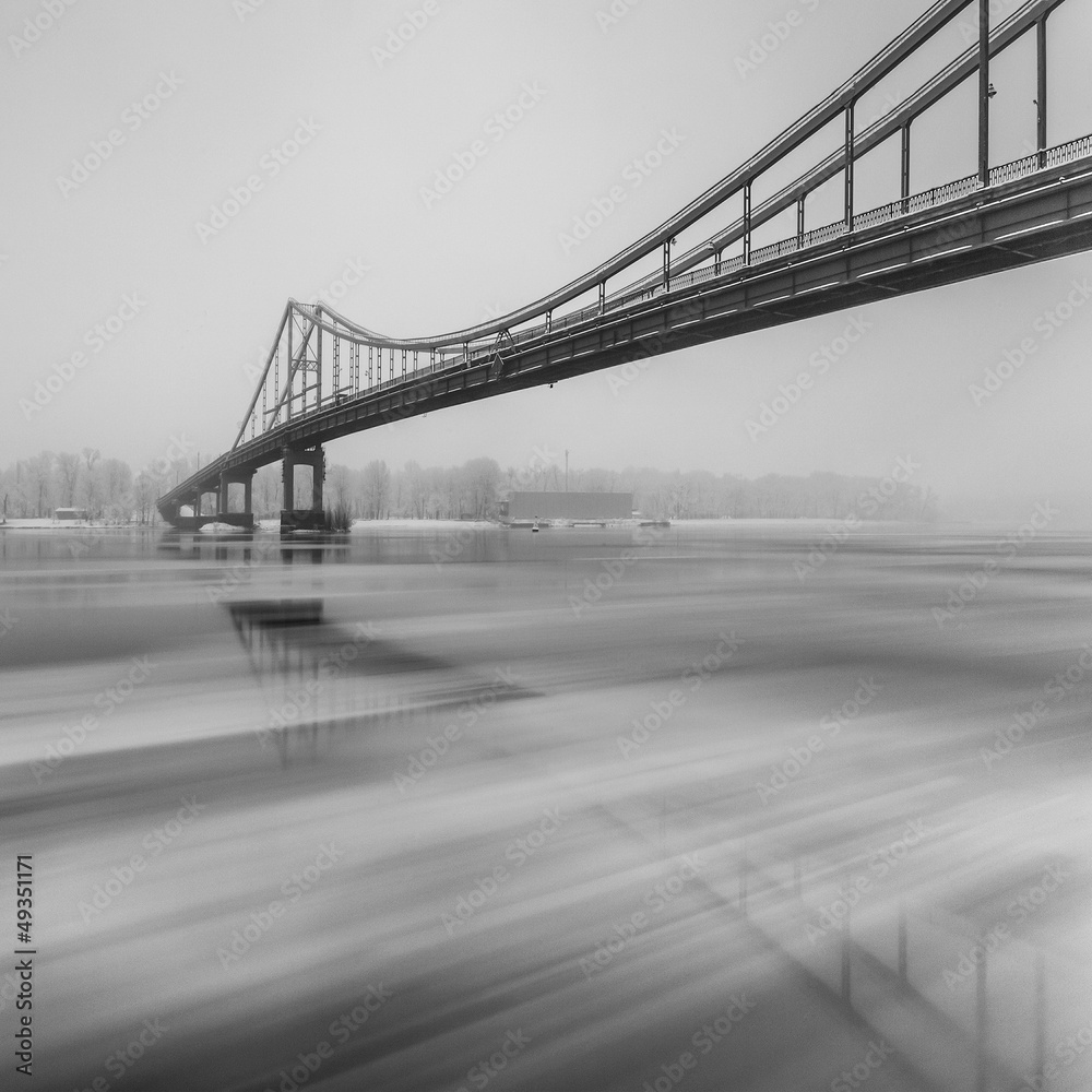 Ice is broken. Footbridge in winter Kiev. Black and white.