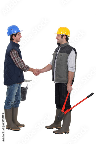 Two manual workers greeting each other © auremar