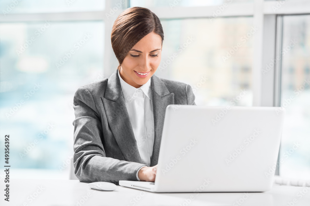 Busy caucasian business woman using laptop at office desk Busy caucasian business woman using laptop at office desk