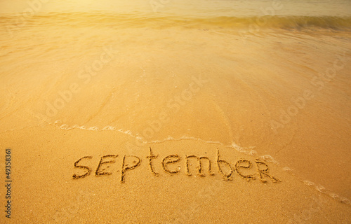 September - written in sand on beach texture