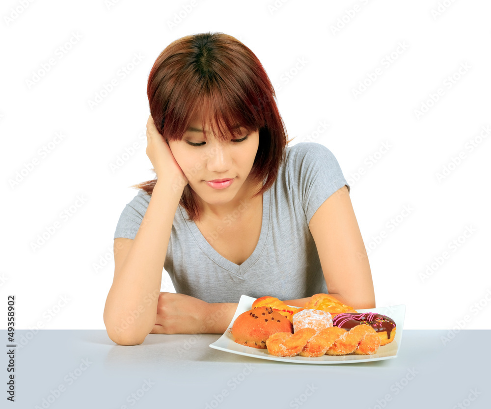 Isolated young asian woman with a donuts on the table Isolated young asian woman with a donuts on the table