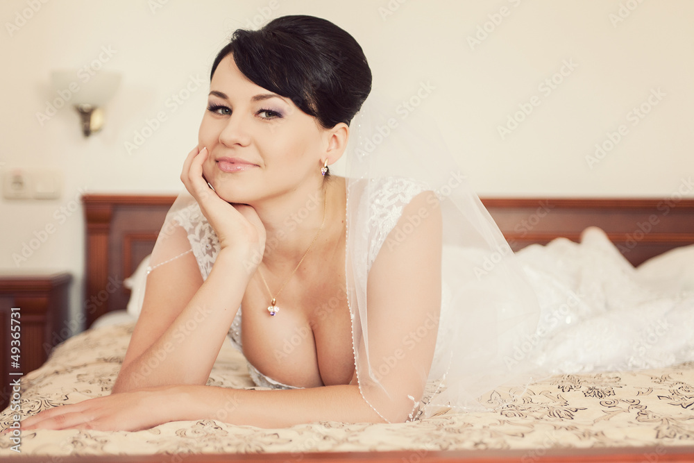 Portrait of happy beautiful bride lying on bed in wedding day Portrait of happy beautiful bride lying on bed in wedding day