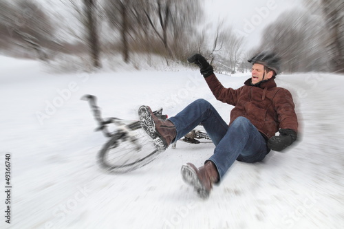 Fahrradunfall im Winter mit Mann beim Fallen photo