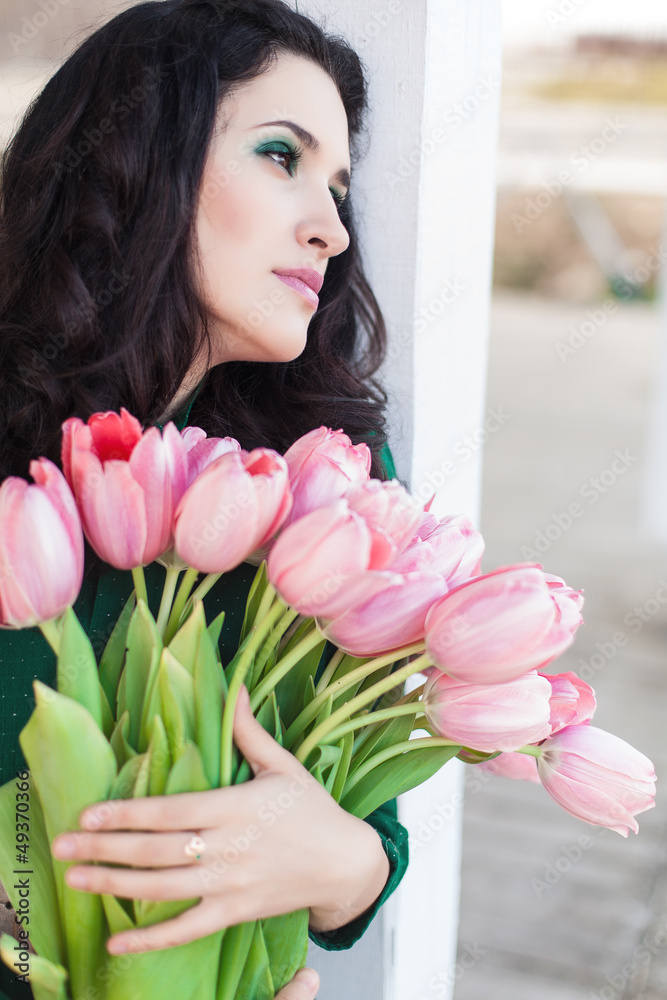 Beautiful young brunette woman with pink tulips Beautiful young brunette woman with pink tulips