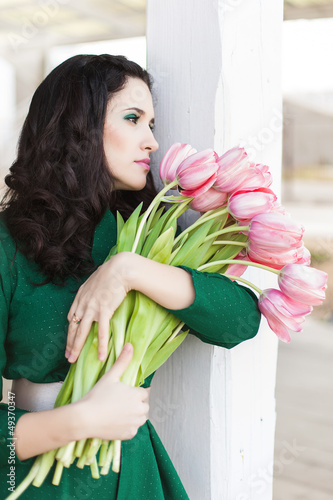 Beautiful young brunette woman with pink tulips