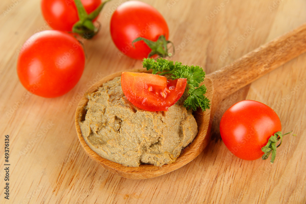 Fresh pate on wooden spoon, on wooden background