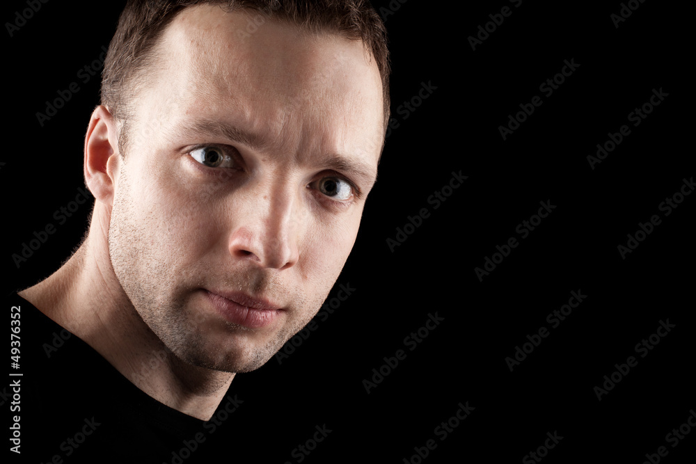 Young Caucasian man's portrait. Close-up face in the dark Young Caucasian man's portrait. Close-up face in the dark