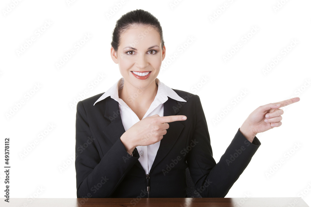 Businesswoman at the desk pointing to empty copy space Businesswoman at the desk pointing to empty copy space