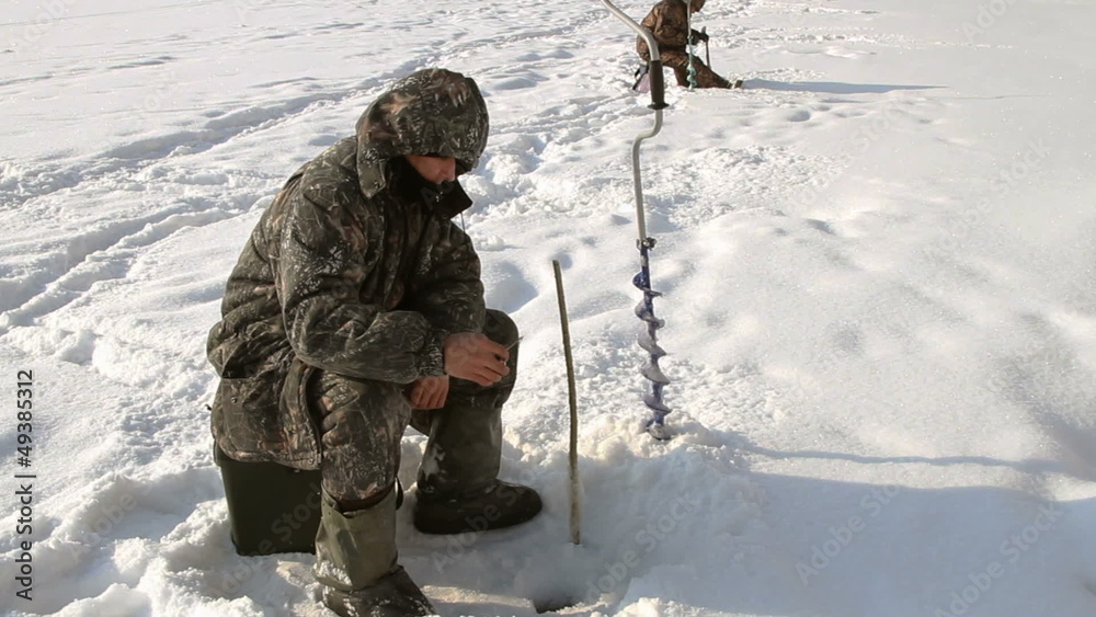 The fisherman on winter fishing in frosty day The fisherman on winter fishing in frosty day