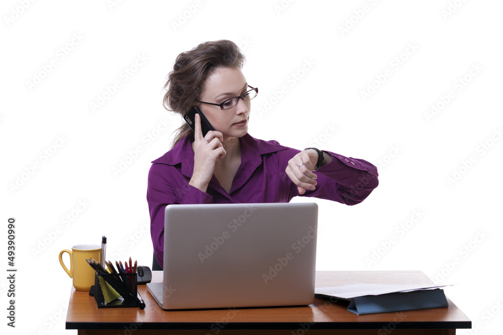 Businesswoman looking at her watch at a table isolated on white Businesswoman looking at her watch at a table isolated on white