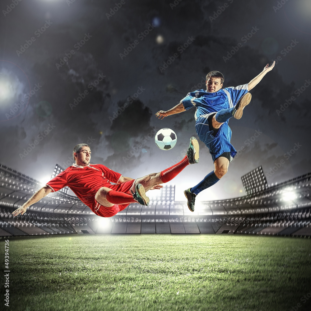 two football players striking the ball two football players striking the ball