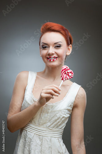 happy red-haired girl holding candy