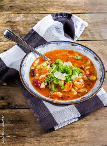 Minestrone vegetable soup with parmesan cheese .