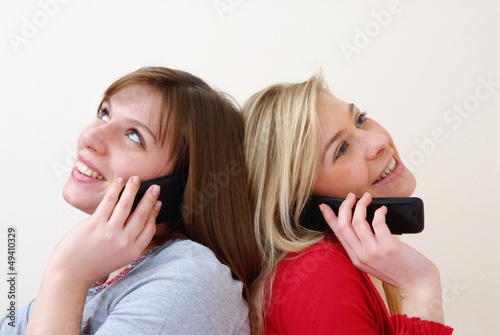 Dos mujeres conversando por teléfono celular. photo