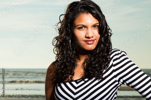 Pretty indian girl with long hair on the beach in summer.