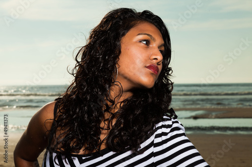 Pretty indian girl with long hair on the beach in summer.